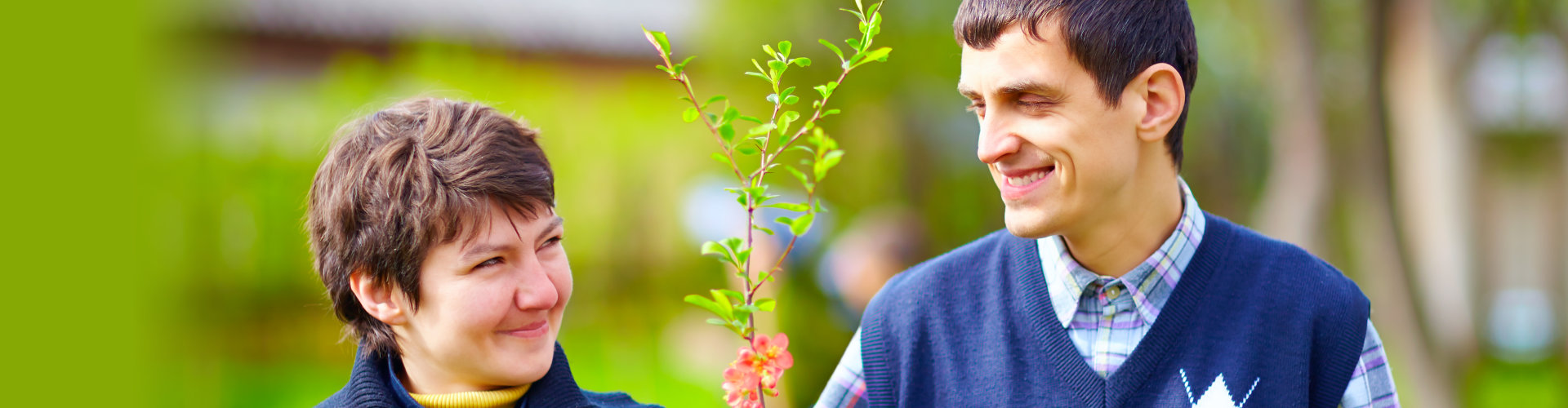 a man and a woman with disability holding a plant